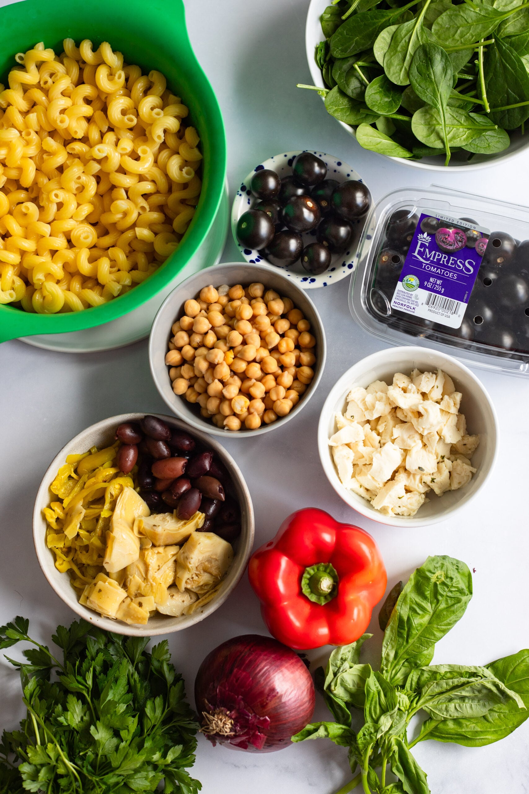 Mediterranean pasta salad ingredients on a white background. 