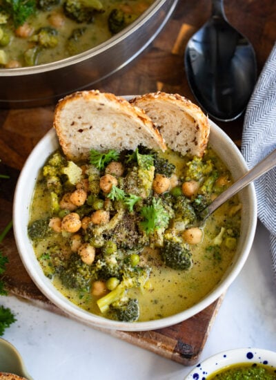 creamy broccoli and chickpeas in a bowl with a slice of sourdough.