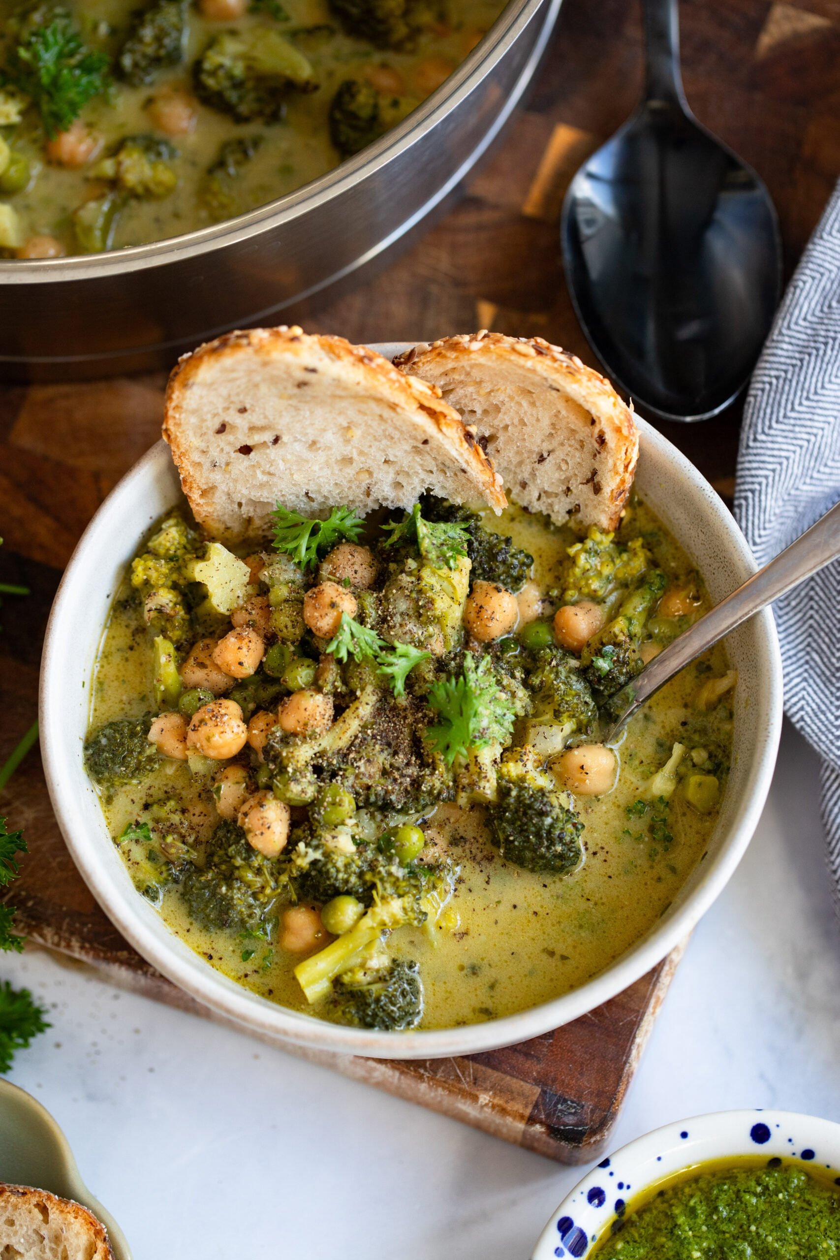 creamy broccoli and chickpeas in a bowl with sourdough