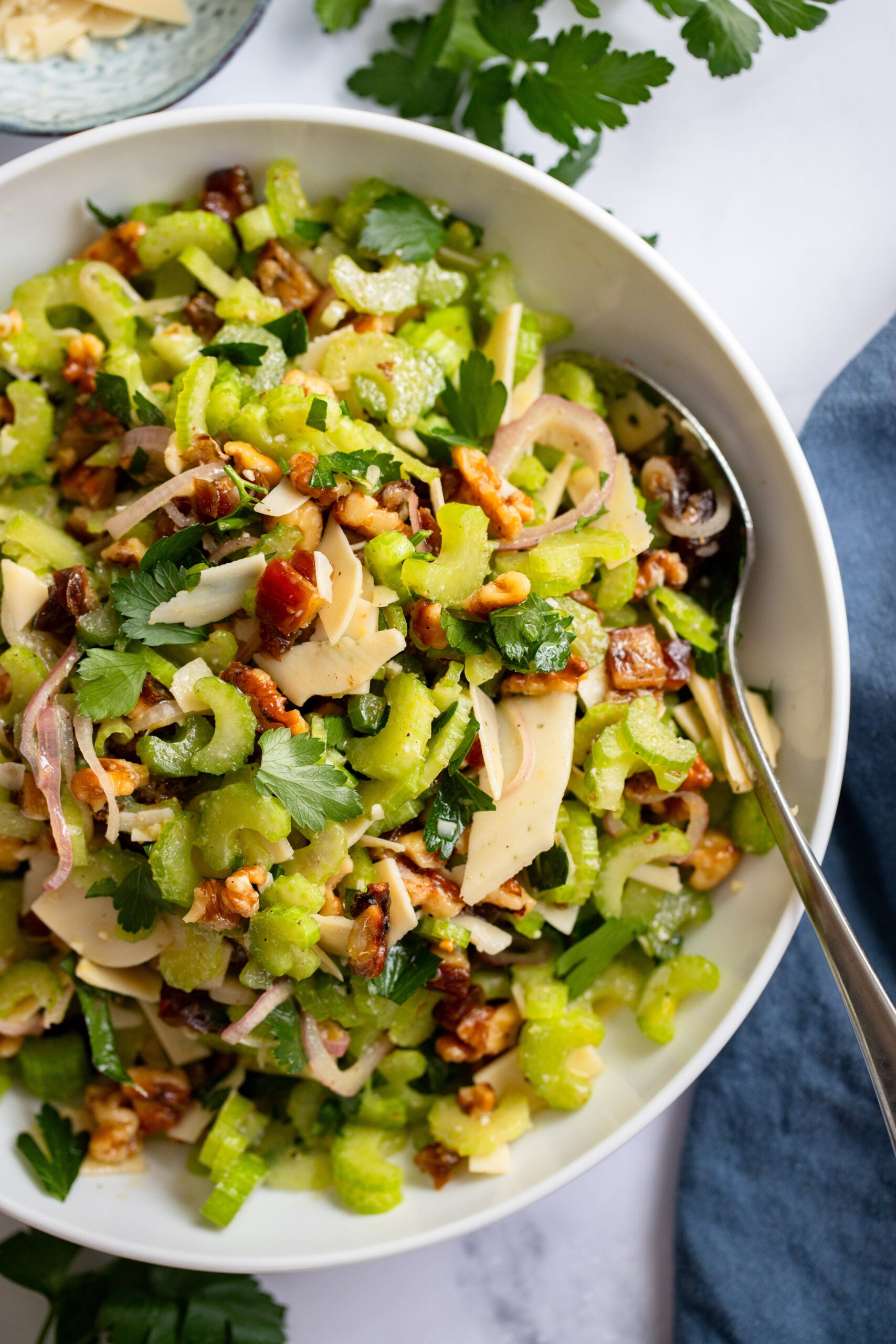 close up shot of celery salad in a white bowl