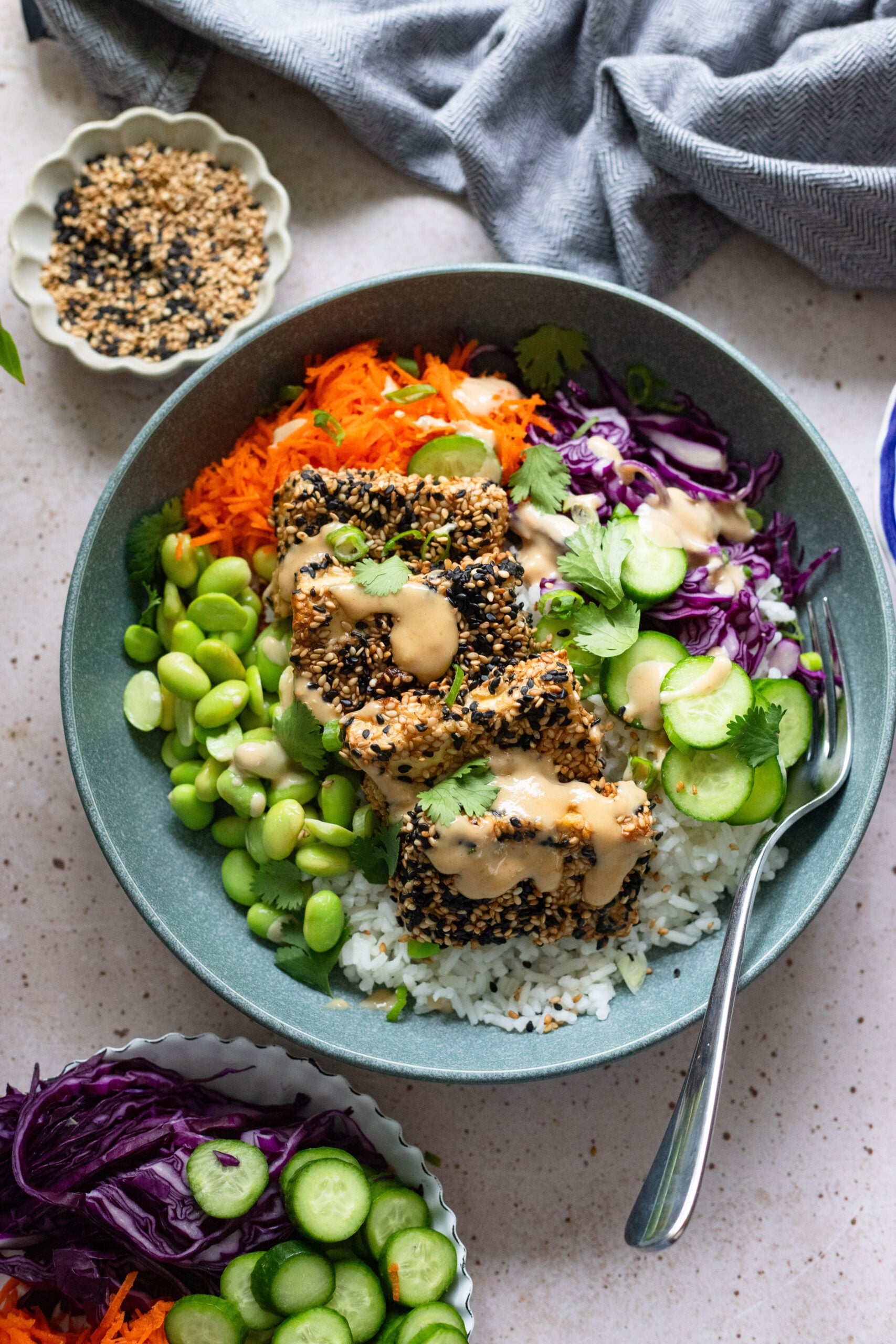 sesame crusted tofu with tahini sauce in blue bowl