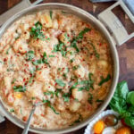 creamy tomato gnocchi in a skillet garnished with fresh basil