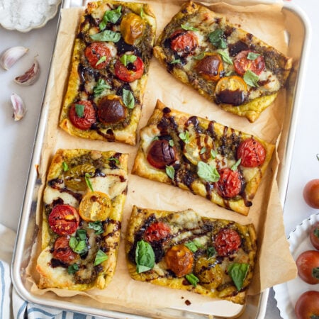 tomato basil tarts on a parchment lined baking sheet