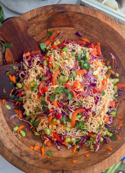 cold ramen noodle salad mixed up in a large wooden serving bowl