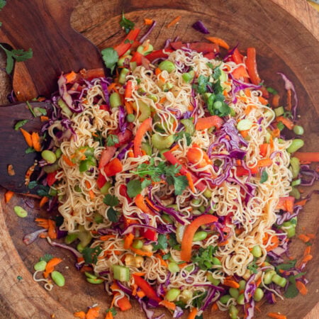 cold ramen noodle salad mixed up in a large wooden serving bowl