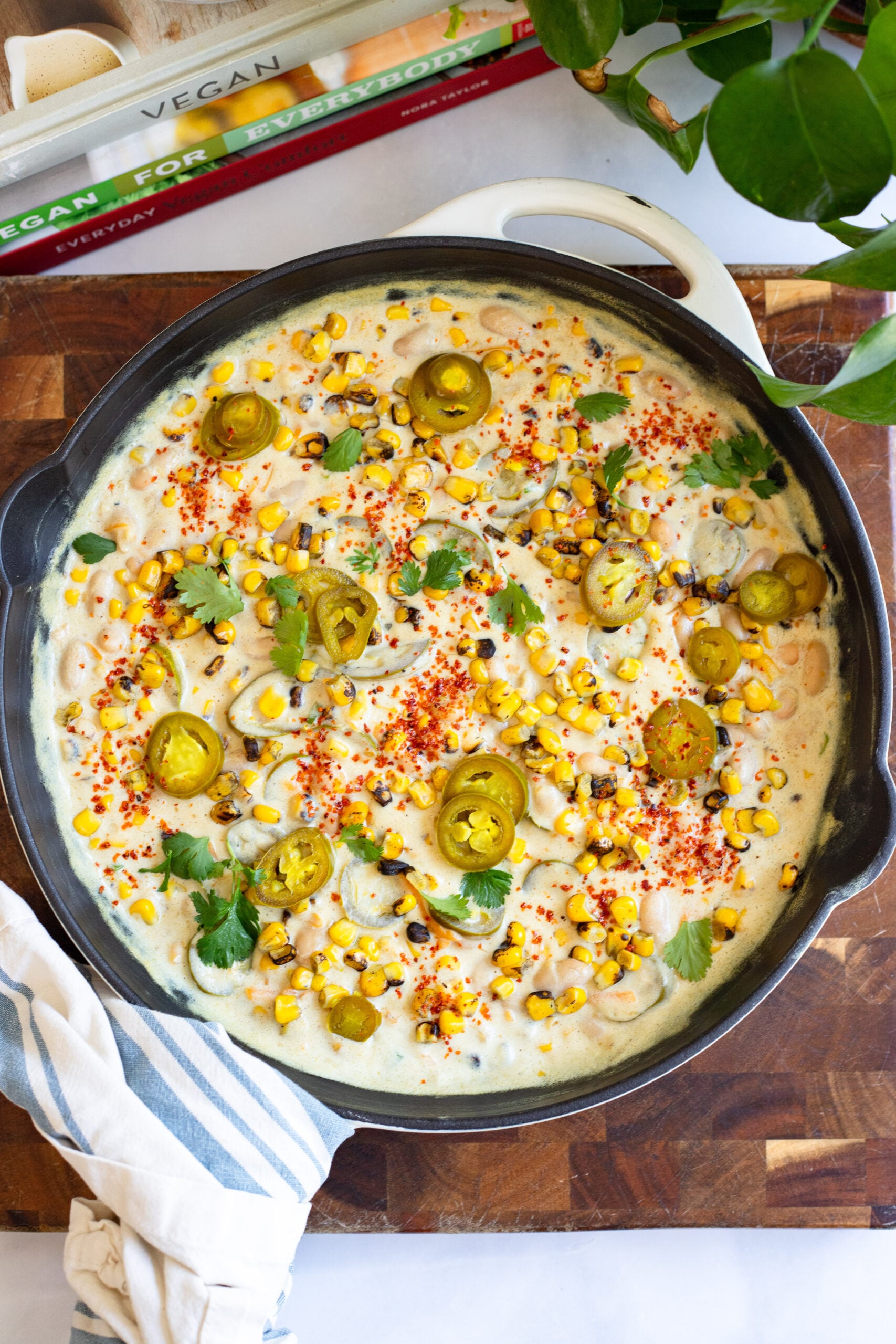 creamy corn and jalapeño bean dip in a skillet garnished with cilantro