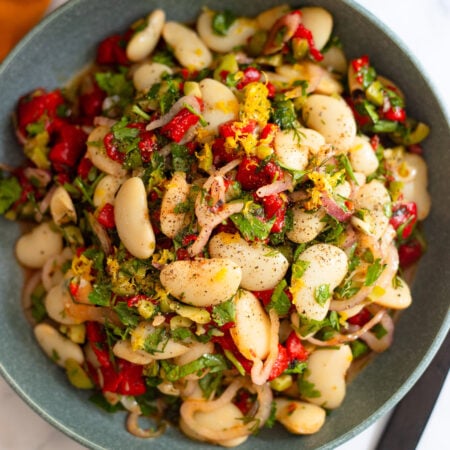marinated butter beans in a blue serving bowl