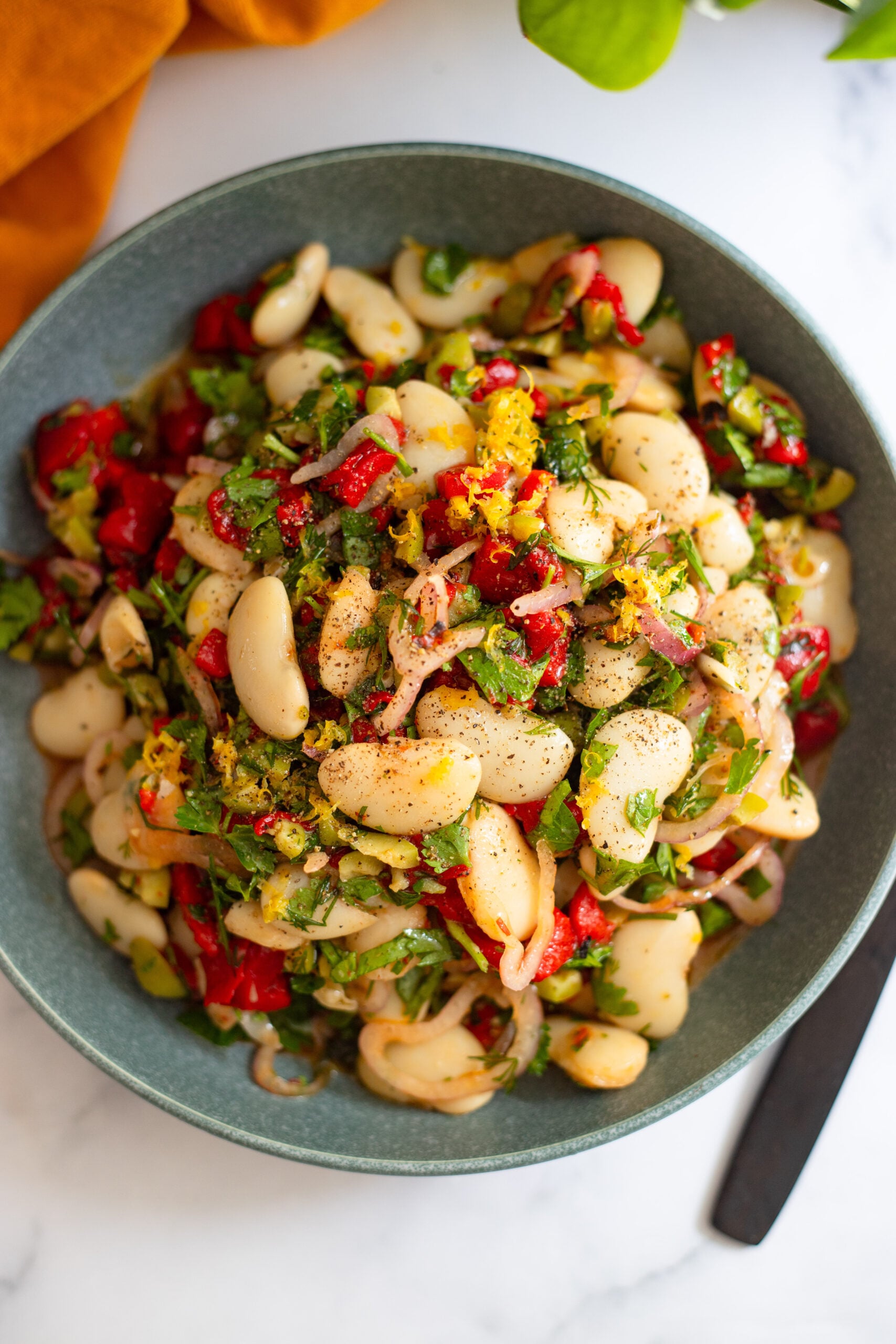 marinated butter bean salad in a blue serving bowl