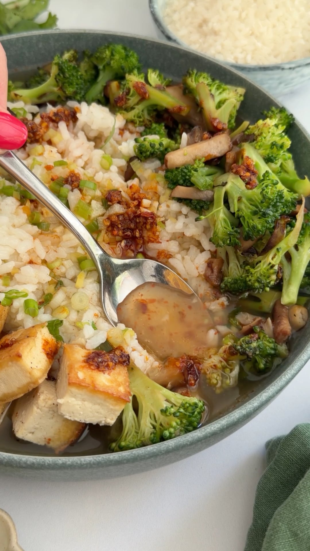 spoon dipping into brothy rice bowl