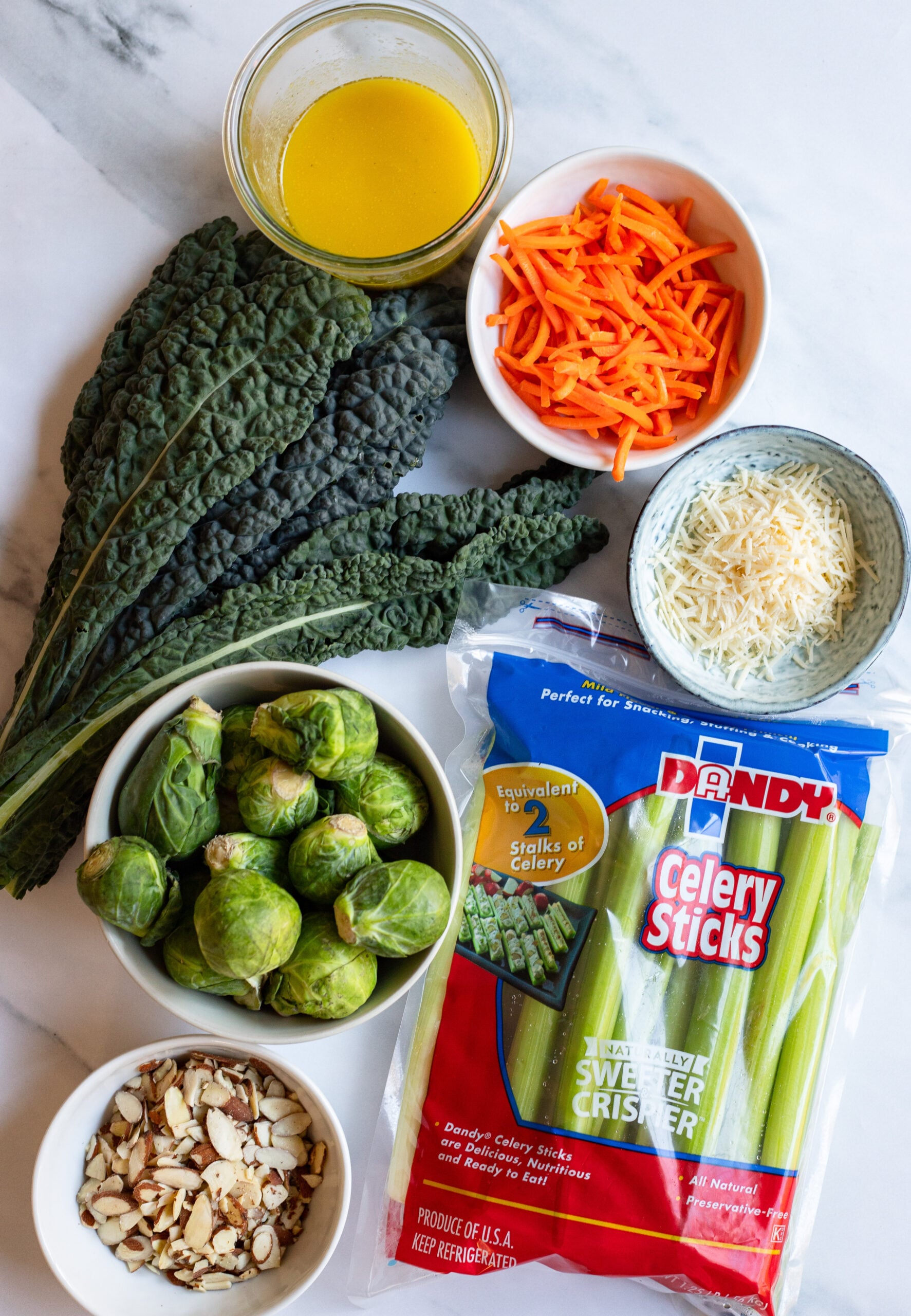 kale, celery, and brussels sprouts slaw ingredients on a white background