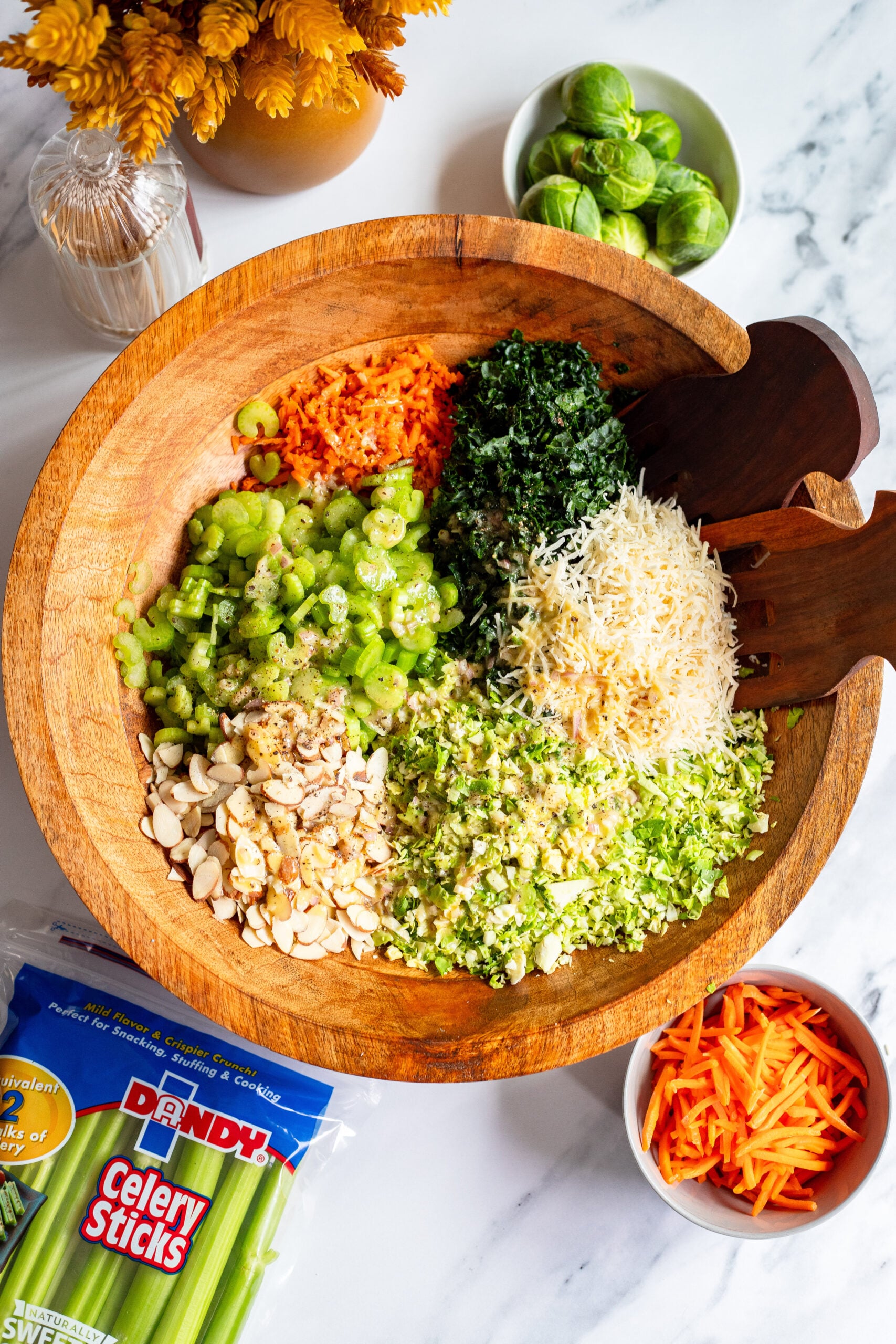brussels sprouts slaw in a large wooden serving bowl before tossing
