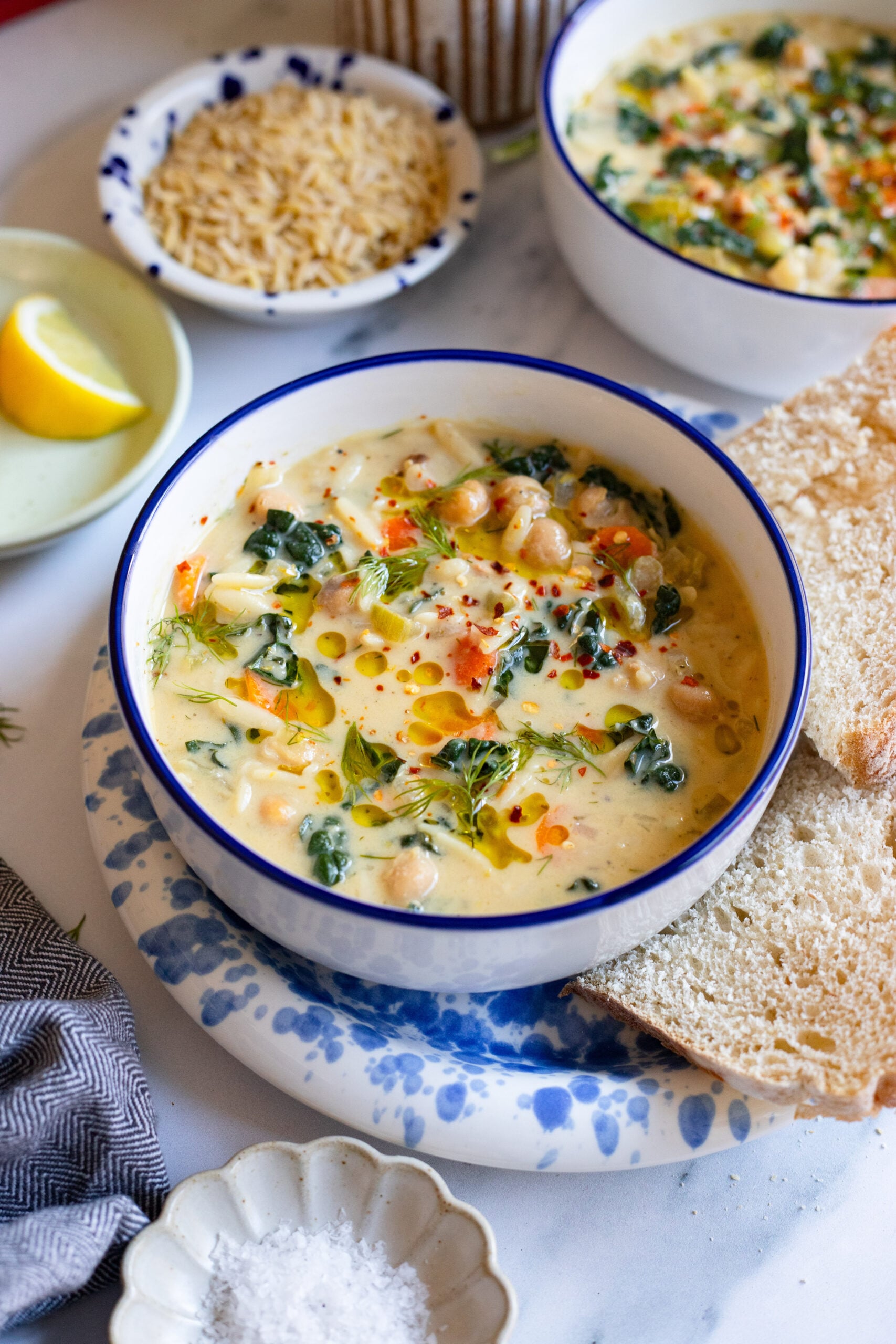 lemon chickpea soup garnished with fresh dill in a bowl with bread