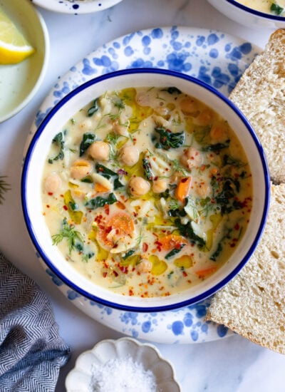 lemon chickpea orzo soup in a bowl with bread on the side