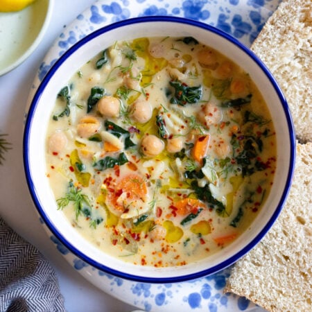 lemon chickpea orzo soup in a bowl with bread on the side